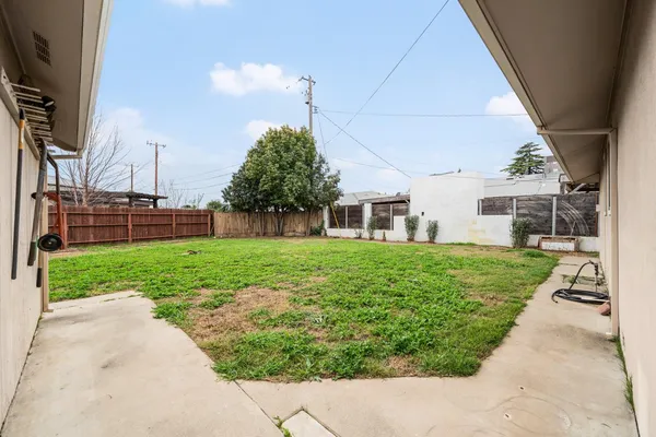 a view of an house with backyard space and a tree