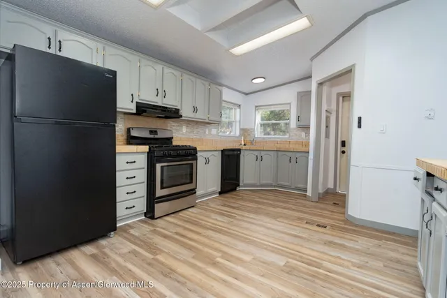 a kitchen with stainless steel appliances granite countertop a refrigerator and a stove