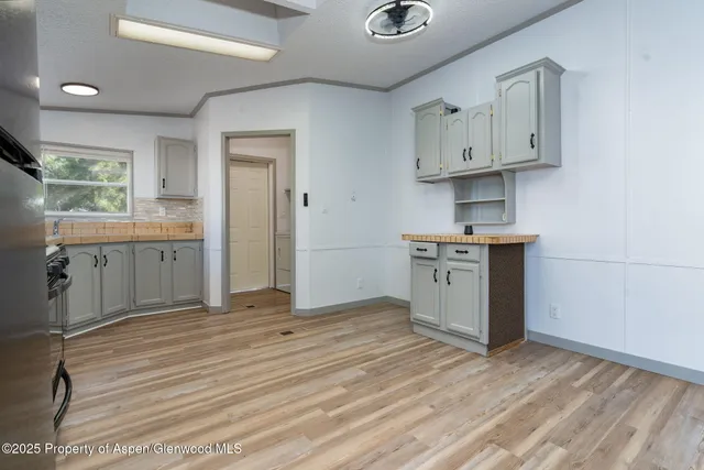 a kitchen with stainless steel appliances a refrigerator stove and wooden floor