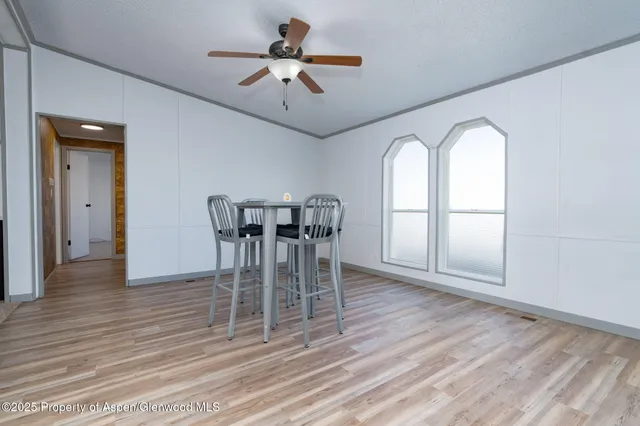 a view of a dining room with furniture a chandelier and wooden floor