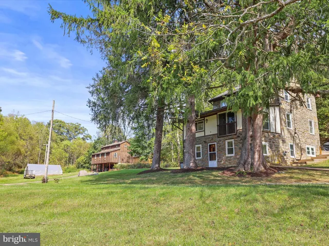 a view of a house with backyard and a tree