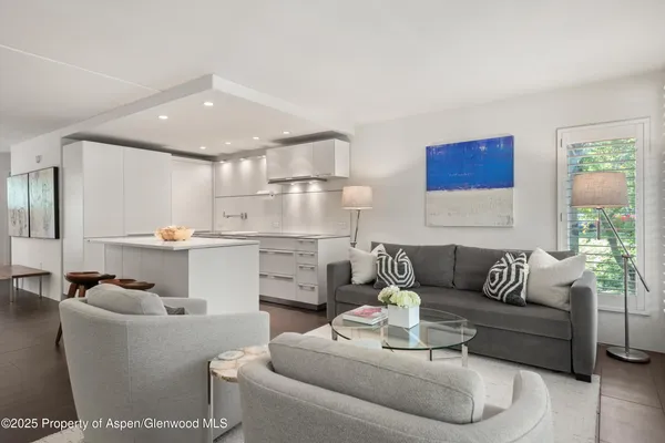 a living room with furniture and kitchen view