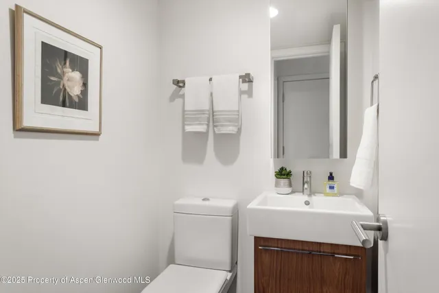 a bathroom with a sink toilet and mirror