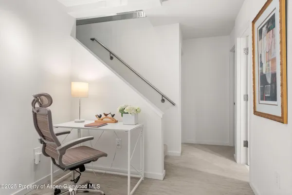 a view of a workspace with furniture and a window