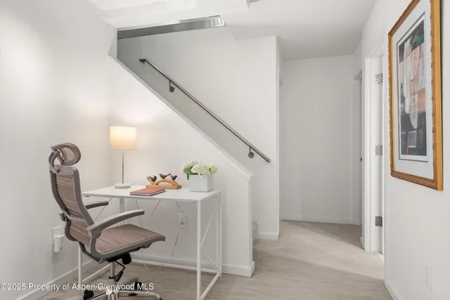 a view of a workspace with furniture and a window