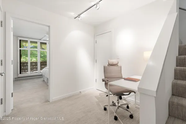 a view of a workspace with furniture and a window