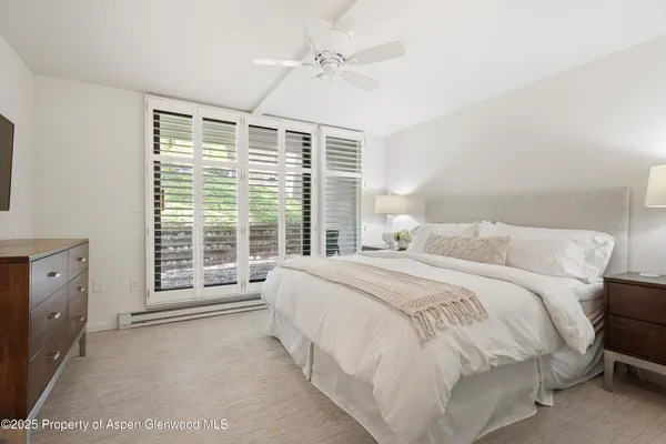 a spacious bedroom with a bed and a window