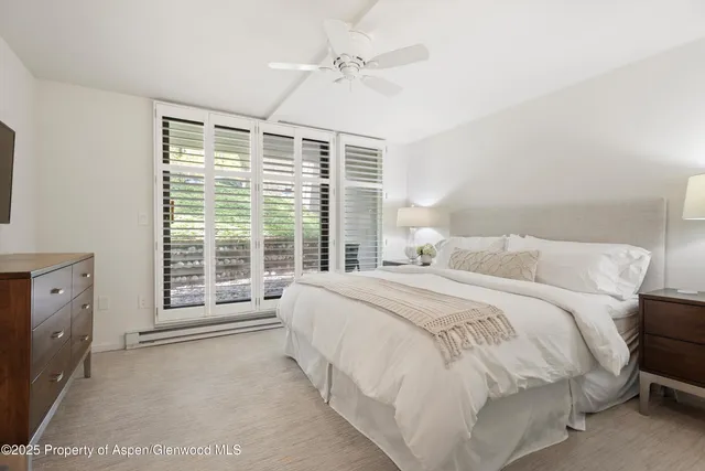 a spacious bedroom with a bed and a window