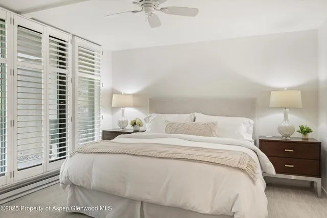 a large bedroom with a bed and a night stand