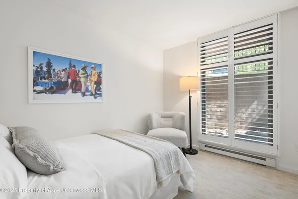 a bedroom with a bed and a painting on the wall