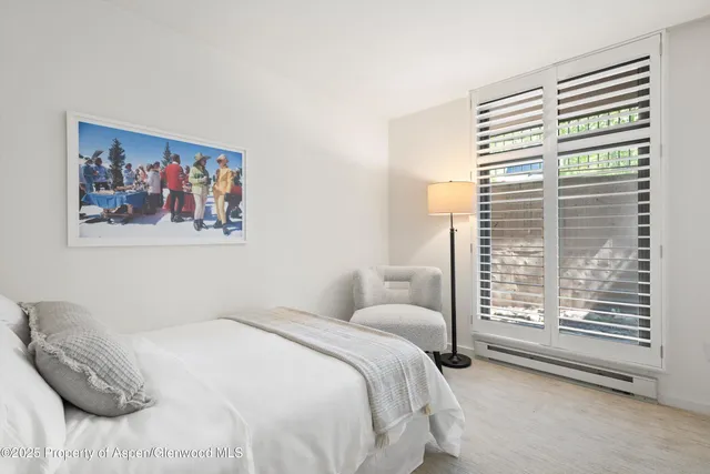 a bedroom with a bed and a painting on the wall