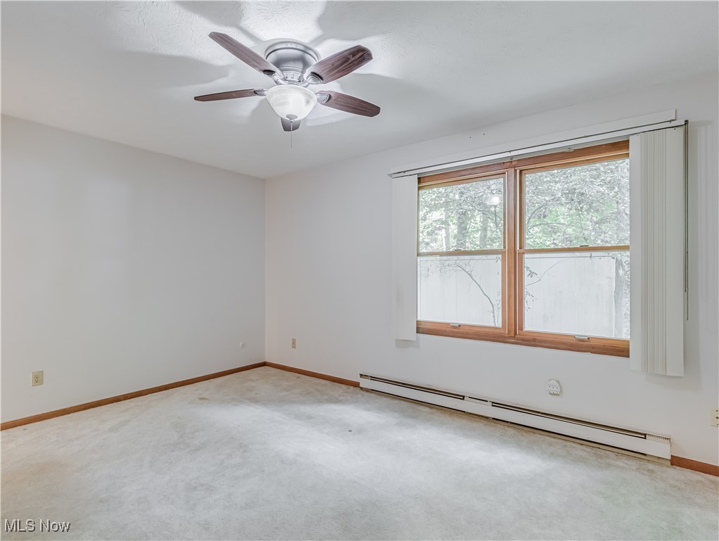 3087 Baughman Road Clinton, OH 44216 - Photo 14 of 24 Carpeted empty room featuring a baseboard radiator and ceiling fan