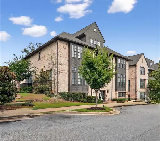 a front view of a house with a garden and trees
