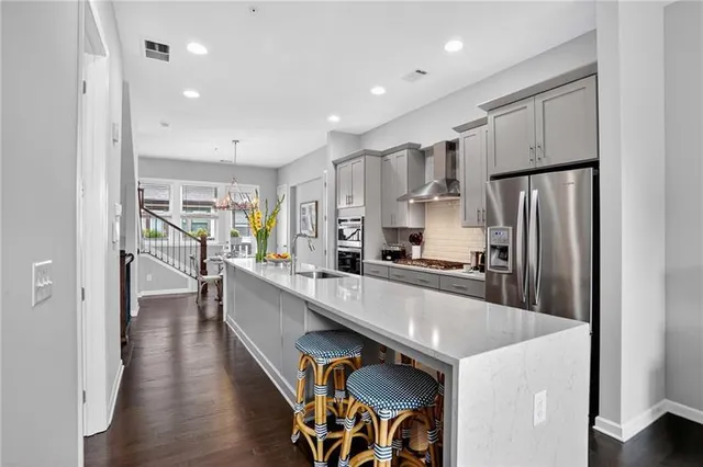 a large kitchen with stainless steel appliances lots of counter space and wooden floor