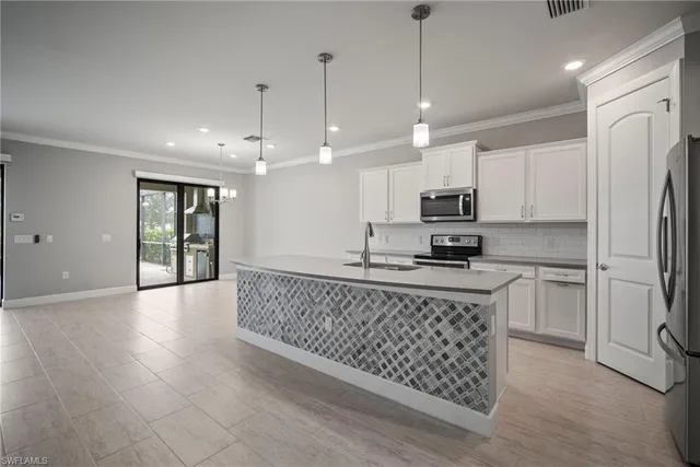 a kitchen with stainless steel appliances granite countertop a stove a refrigerator a sink a microwave and island