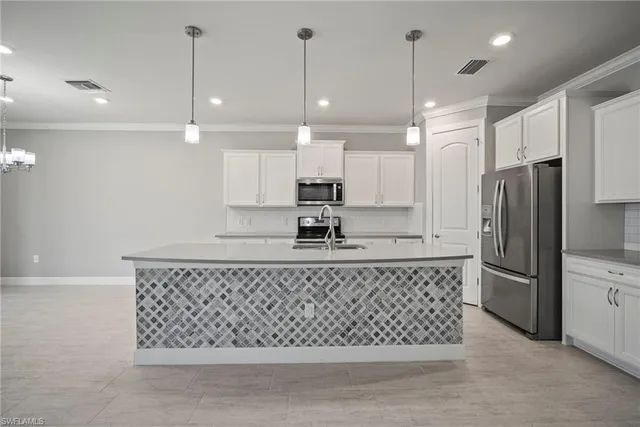 a kitchen with stainless steel appliances granite countertop a refrigerator a sink a stove a microwave and white cabinets