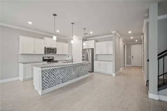 a kitchen with stainless steel appliances kitchen island granite countertop a refrigerator and a stove top oven
