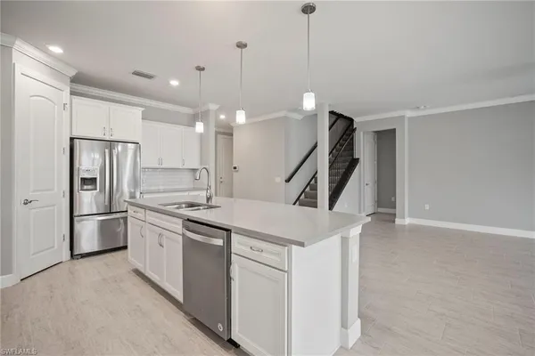 a kitchen with white cabinets and stainless steel appliances