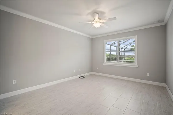 an empty room with a window and a fan
