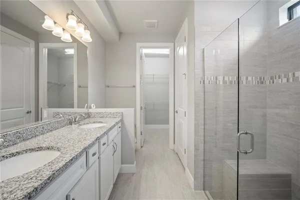 a bathroom with a glass shower door and a mirror