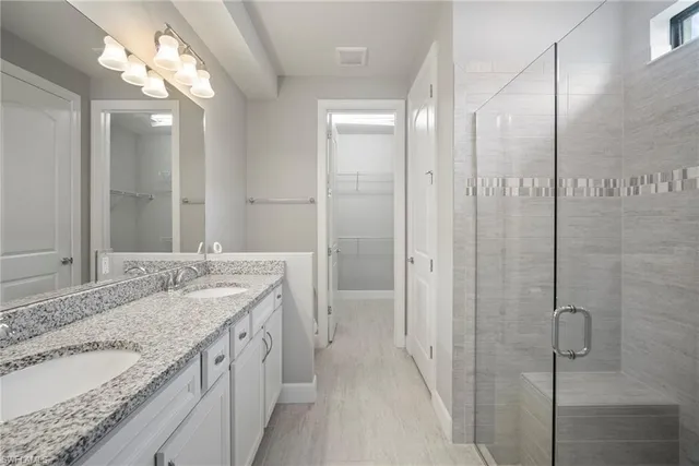a bathroom with a glass shower door and a mirror