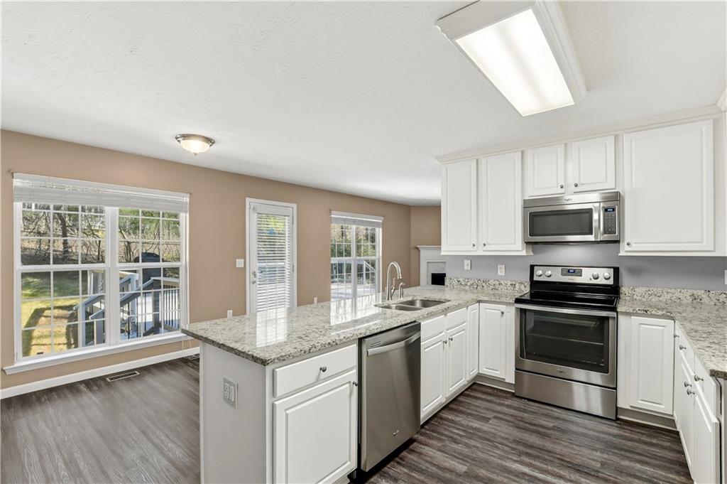 5976 Bowers Road Stone Mountain, GA 30087 - Photo 9 of 31 a kitchen with stainless steel appliances granite countertop a stove and a sink