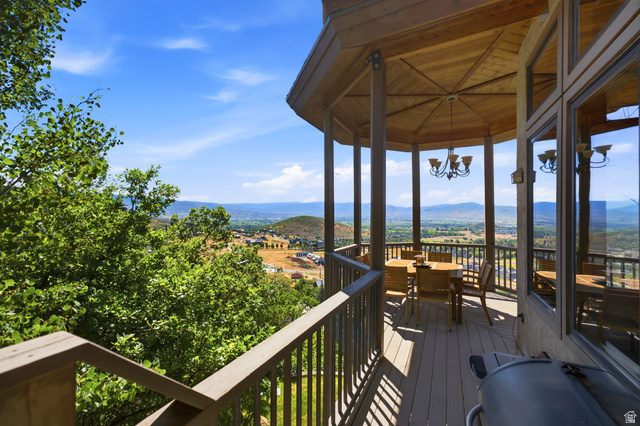 335 Bern Way Midway, UT 84049 - Photo 27 of 88 Expansive outdoor deck featuring a gazebo with a wood-plank ceiling, metal chandelier, and a panoramic mountain backdrop