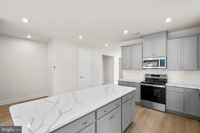 a kitchen with granite countertop white cabinets and stainless steel appliances