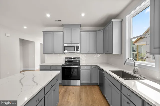 a kitchen with stainless steel appliances granite countertop a sink stove and refrigerator