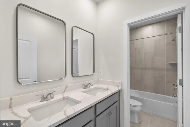 a bathroom with a bathtub shower sink vanity and toilet