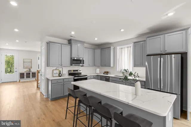 a kitchen with sink a refrigerator and chairs