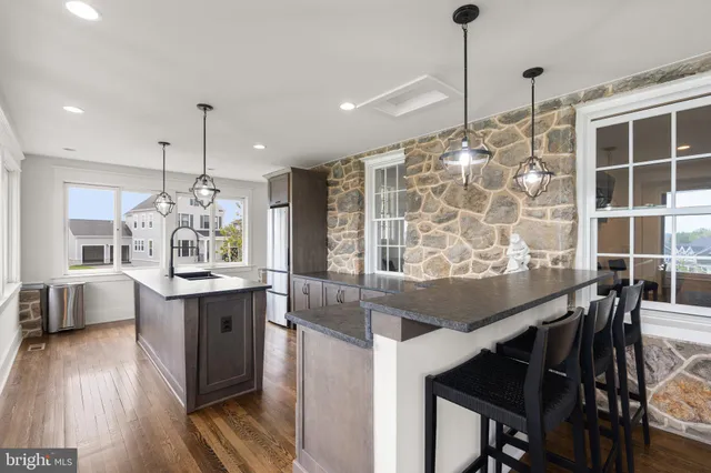 a kitchen with granite countertop a table chairs stove and wooden floor