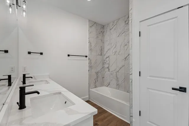 a bathroom with a tub a sink and a shower