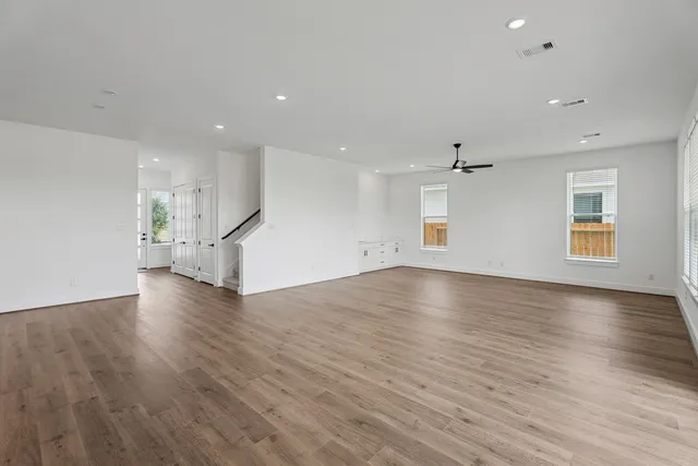 a view of empty room with wooden floor and windows