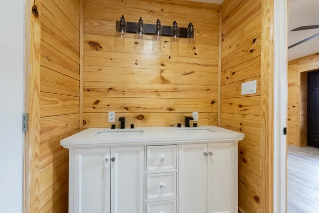 a view of an empty room with wooden floor and a ceiling fan
