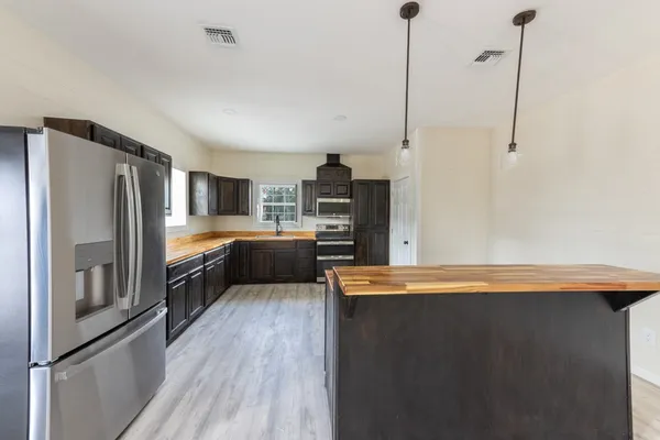 a kitchen with stainless steel appliances granite countertop wooden cabinets a stove top oven a sink and dishwasher