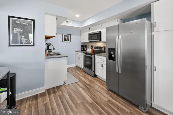a kitchen with stainless steel appliances a refrigerator and a stove top oven