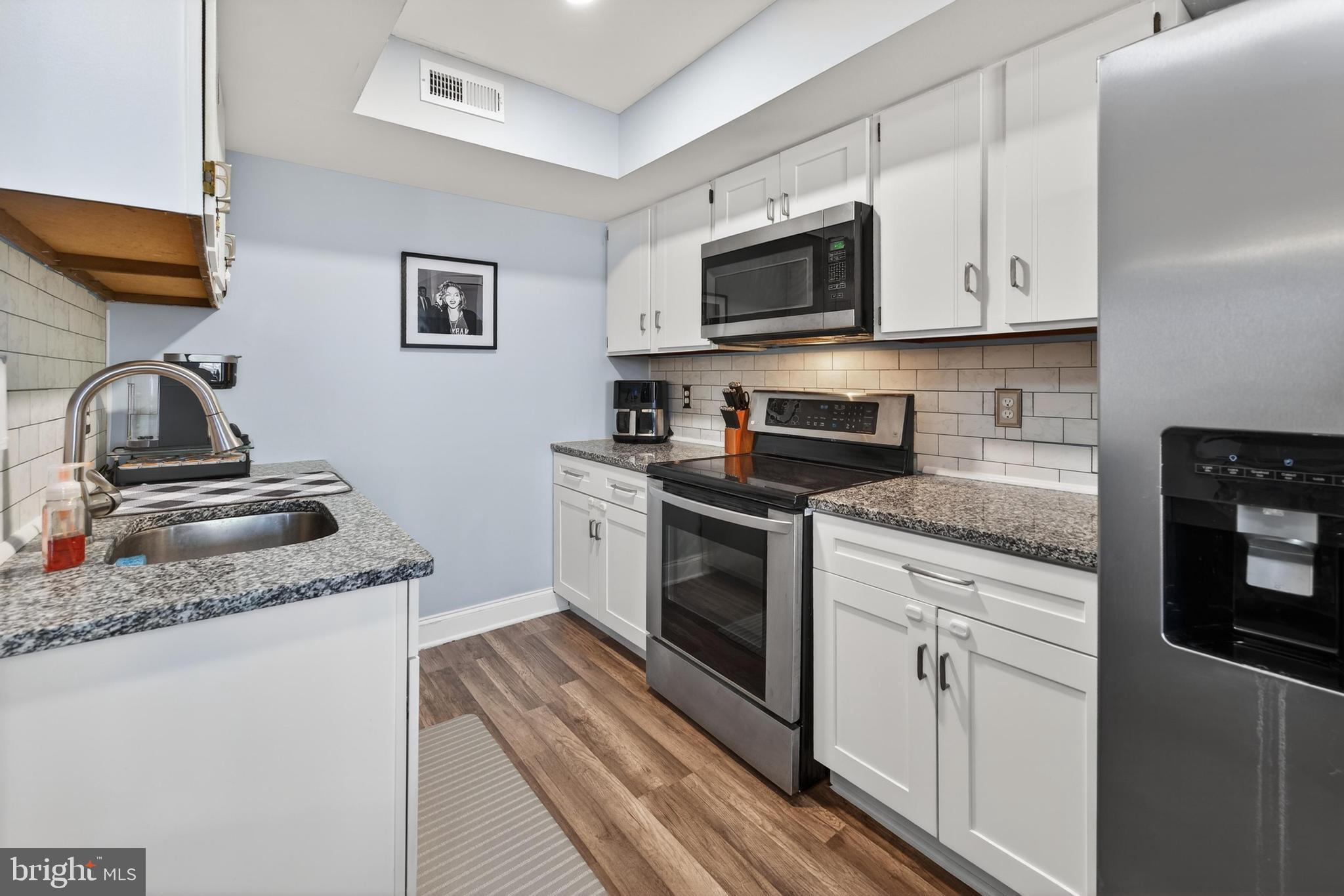 115 East Kings Highway, Unit 360 Maple Shade, NJ 08052 - Photo 13 of 20 a kitchen with granite countertop white cabinets stainless steel appliances and a counter space