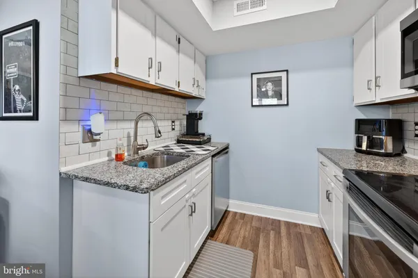 a kitchen with stainless steel appliances granite countertop a sink stove and cabinets