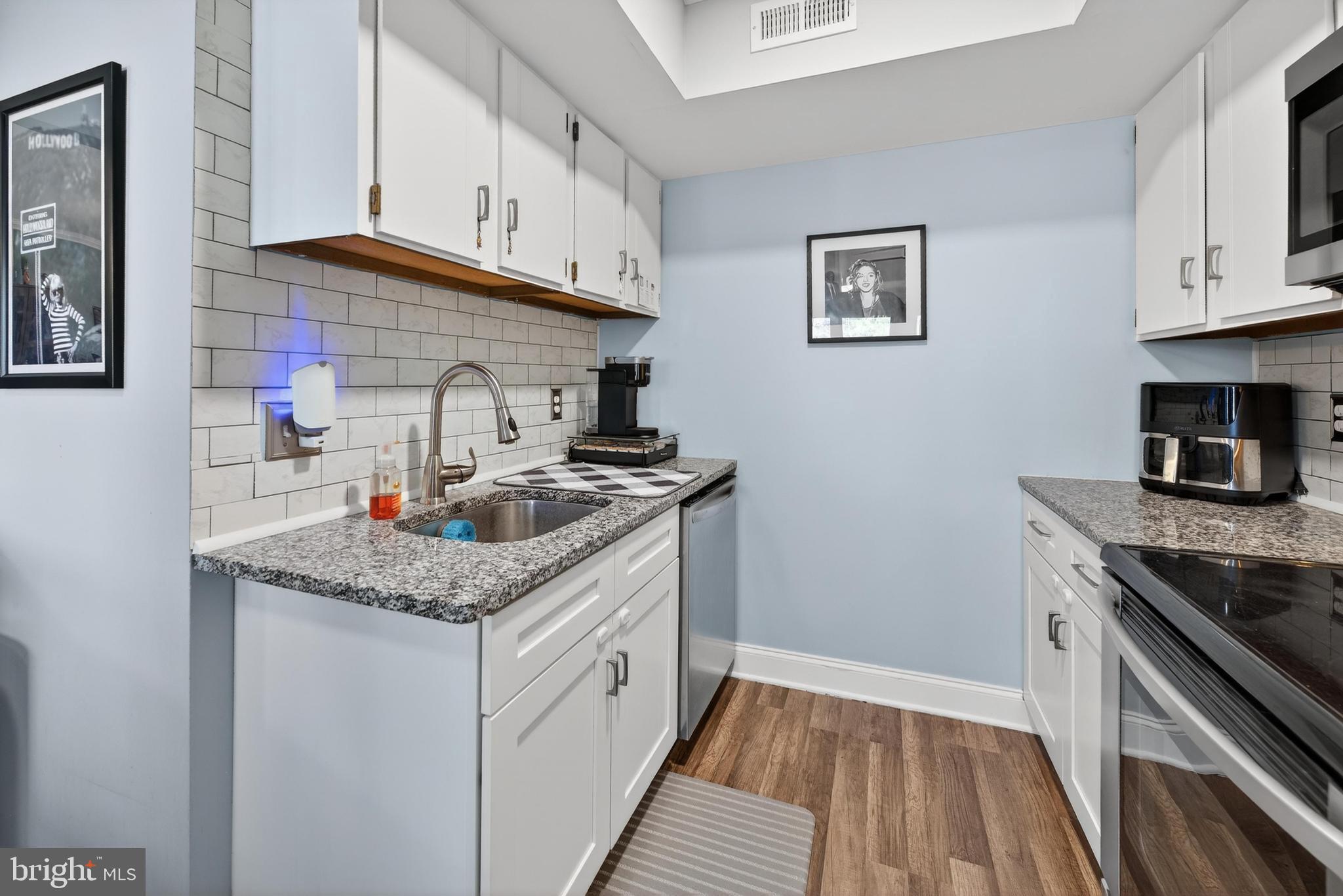 115 East Kings Highway, Unit 360 Maple Shade, NJ 08052 - Photo 15 of 20 a kitchen with stainless steel appliances granite countertop a sink stove and cabinets