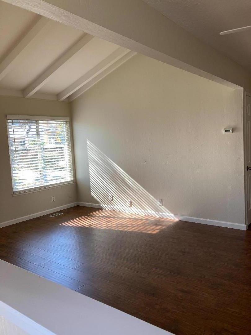 1010 Bryant Way, Unit E Sunnyvale, CA 94087 - Photo 3 of 13 an empty room with wooden floor cabinet and windows