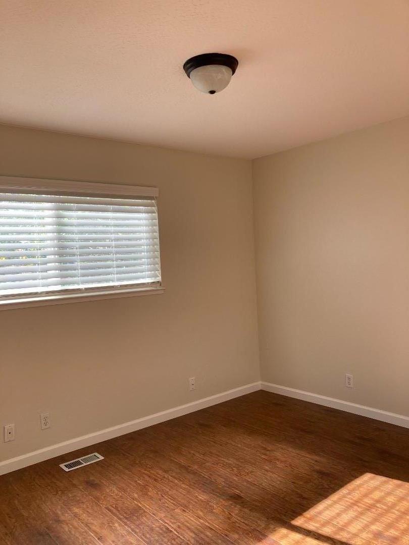1010 Bryant Way, Unit E Sunnyvale, CA 94087 - Photo 4 of 13 a view of an empty room with wooden floor and a window