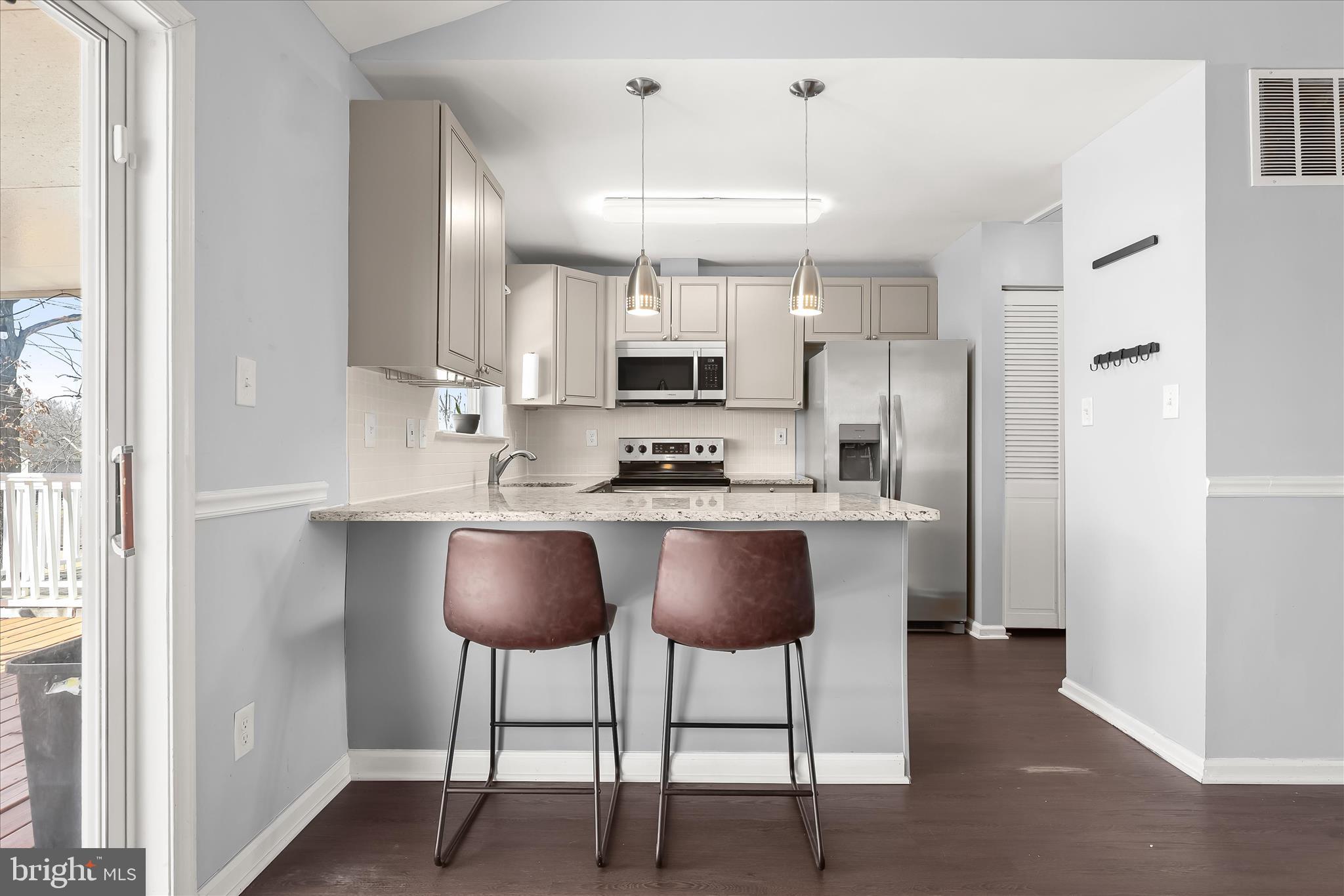 8624 Castlemill Circle Nottingham, MD 21236 - Photo 12 of 34 a kitchen with granite countertop a counter space chairs stainless steel appliances and cabinets