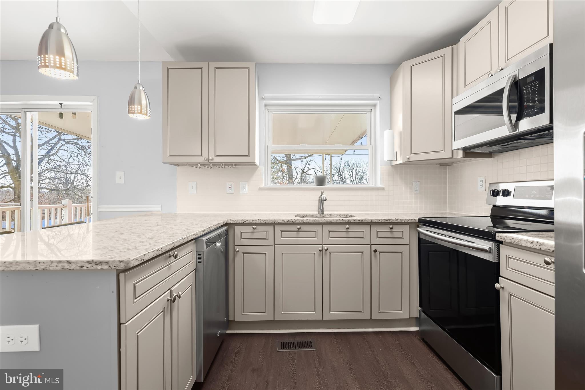 8624 Castlemill Circle Nottingham, MD 21236 - Photo 14 of 34 a kitchen with stainless steel appliances granite countertop a sink and dishwasher a stove top oven with wooden floor