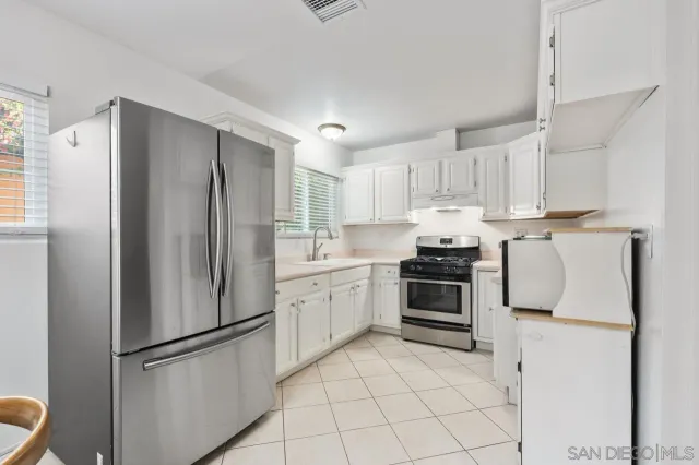 a living room with furniture a flat screen tv and next to a large window