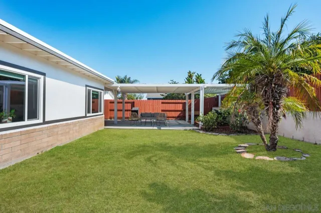 a view of a patio with a table chairs and a barbeque