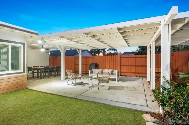 a dining room with wooden floor a chandelier fan a wooden table and chairs