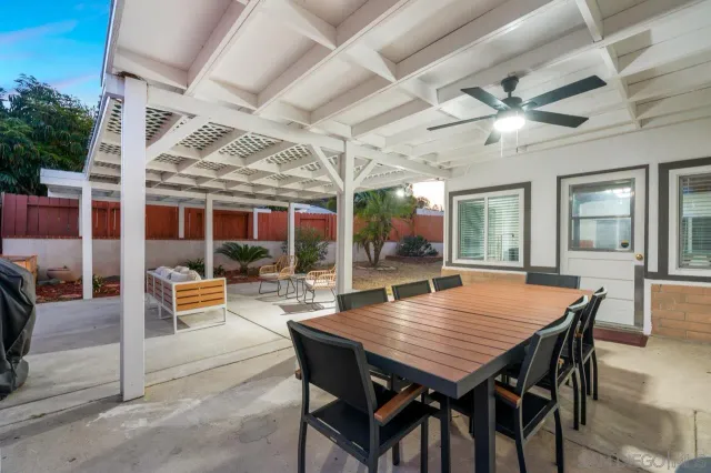 a backyard of a building with potted plants and large tree