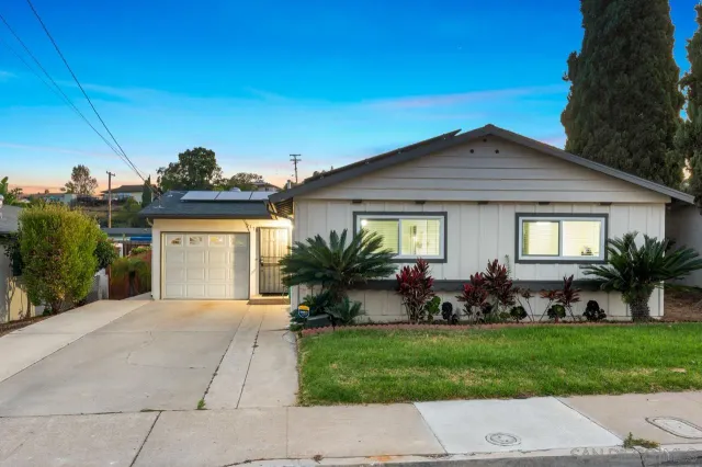 a front view of a house with a garden