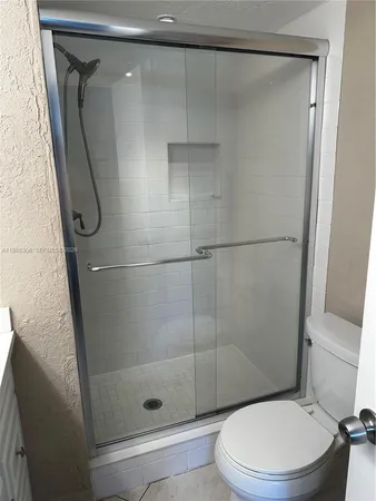 a white toilet and shower in a bathroom